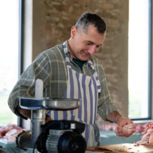 Aurélien réalise des saucisses lors du stage découpe de porc aux gaties