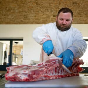 Tony le boucher découpe de la viande pour le stage de cochon aux gaties