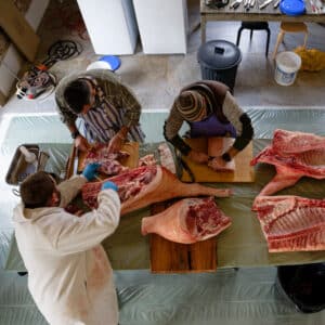 Travail en groupe lors de la découpe du porc